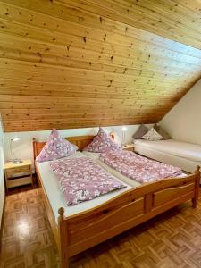 two beds in a room with a wooden ceiling at Hugenhof Kirchzarten bei Freiburg in Kirchzarten