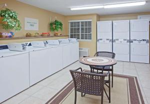 cocina con armarios blancos, mesa y sillas en Sonesta Simply Suites Houston Galleria Medical Center en Houston