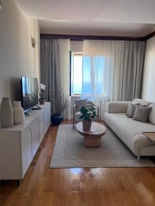 a living room with a white couch and a tv at Penthouse Fantasia in Dubrovnik