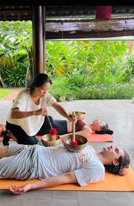 a group of people sitting on the floor doing yoga at Chez Mimosa Rice Farm Hoi An - New address DX18, Thanh Nhut, Cam Thanh in Hoi An