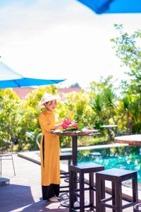 Una donna in piedi accanto a un tavolo con del cibo sopra. di Chez Mimosa Rice Farm Hoi An - New address DX18, Thanh Nhut, Cam Thanh a Hoi An