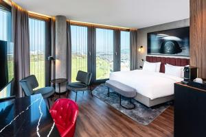 um quarto de hotel com uma cama e uma grande janela em Radisson Blu Hotel at Porsche Design Tower Stuttgart em Stuttgart