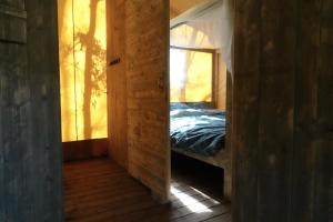 un espejo en una habitación con una cama en ella en La Grisonne - Chalet 3, en Revest-du-Bion