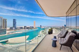balcón con 2 sillas y vistas a la ciudad en Conrad Bahrain Financial Harbour en Manama