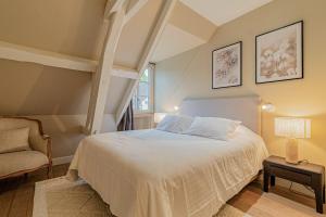 コンピエーニュにあるLE MOULIN DE L'ORTILLEのベッドルーム(白いベッド1台、椅子付)