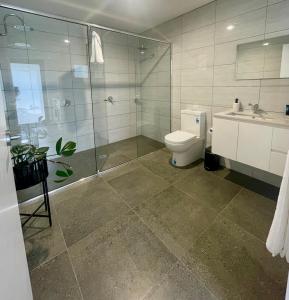 a bathroom with a shower and a toilet and a sink at Four Square Short Stay Accommodation Railton in Railton
