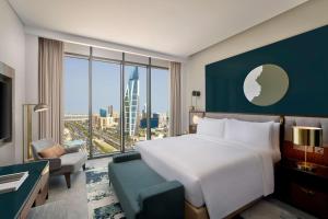 ein Hotelzimmer mit einem Bett und einem großen Fenster in der Unterkunft Conrad Bahrain Financial Harbour in Manama