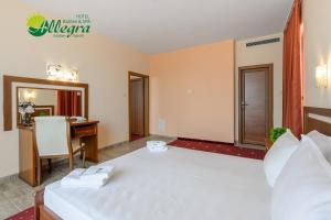a hotel room with a large white bed and a desk at Hotel Allegra Balneo & SPA in Golden Sands