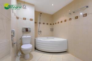 a bathroom with a white tub and a toilet at Hotel Allegra Balneo & SPA in Golden Sands