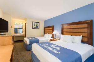 a hotel room with two beds and a flat screen tv at Days Inn by Wyndham Renfro Valley Mount Vernon in Mount Vernon