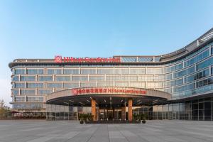 a large building with a sign on top of it at Hilton Garden Inn Huzhou High-Speed Railway Station in Huzhou