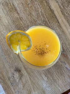 un vaso de zumo de naranja en una mesa de madera en 1000 Borne Caffe Hebergements Insolites, en Entremont