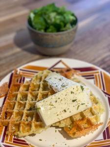 a plate with waffles and cheese and a bowl of broccoli at 1000 Borne Caffe Hebergements Insolites in Entremont