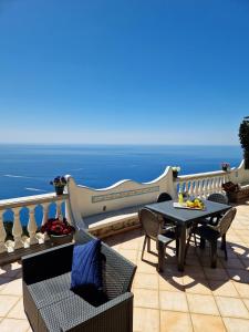 un patio con tavolo e sedie e l'oceano di Your nest on the Path a Positano Altre 26 foto
