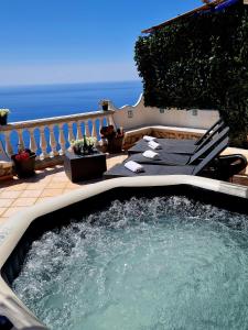 una vasca idromassaggio su un patio con sedie e vista sull'oceano di Your nest on the Path a Positano