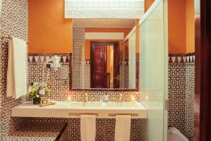 W łazience znajduje się umywalka i lustro. w obiekcie Alhambra Palace Hotel w Grenadzie
