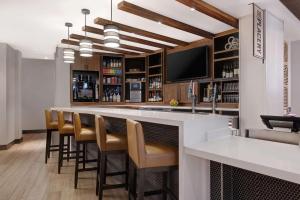 a bar with stools and a bar counter with a television at Hyatt Place Flagstaff in Flagstaff