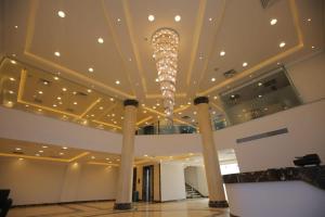een grote lobby met een kroonluchter in een gebouw bij Grand Plaza 6 Octobar in Qaryat ash Shamālī