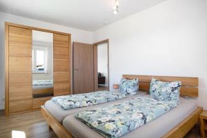 een slaapkamer met 2 bedden en een spiegel bij Ferienhof Lang in Kressbronn am Bodensee