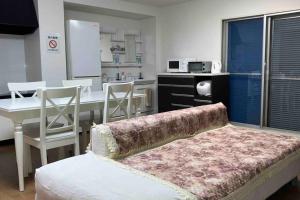 a room with a kitchen with a table and a couch at 望海荘 in Hannan