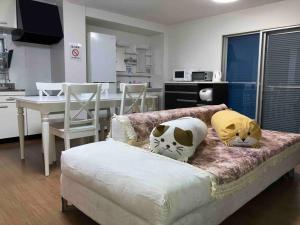 a room with a bed with two cats pillows on it at 望海荘 in Hannan