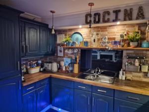 una cucina con armadi blu e lavandino di Unique seafront 2 bedroom apartment a Folkestone