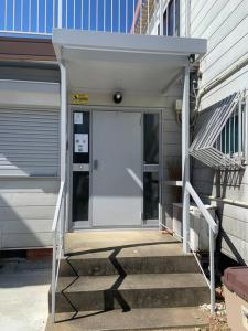 a white door on a building with stairs next to it at 望海荘 in Hannan