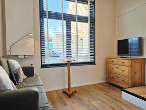 ein Wohnzimmer mit Sofa und Fernseher in der Unterkunft Vakantiewoning met Sauna centrum Domburg DO22 in Domburg