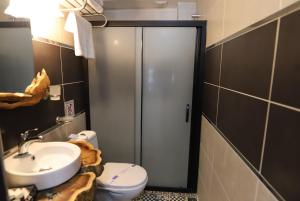 ein Bad mit einer Dusche, einem WC und einem Waschbecken in der Unterkunft Olivia1845 Guest House Ayvalık in Ayvalık