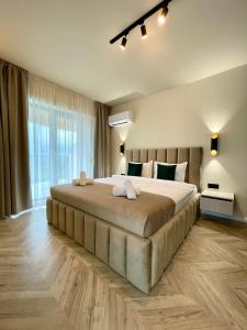 a large bed in a bedroom with a large window at Sunset Studio - 12th Floor in Cluj-Napoca