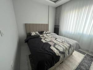 a bedroom with a bed in a white room at CZG SUİTE PREMİNYUM SİTESİ in Alanya
