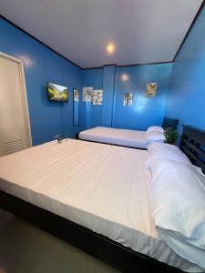 a bedroom with a large bed with blue walls at Halajo bnb transient in Laoag