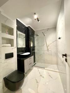 a bathroom with a black toilet and a shower at Sunset Studio - 12th Floor in Cluj-Napoca