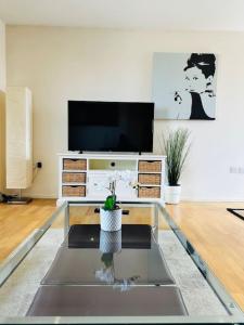 sala de estar con TV y mesa de cristal en Stylish Zone 2 city Apartment, en Londres