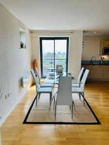 comedor con mesa y sillas blancas en Stylish Zone 2 city Apartment, en Londres