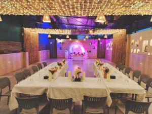 um salão de banquetes com mesas e cadeiras e um palco em Hotel Dhruva-Solapur Pet friendly em Sholapur