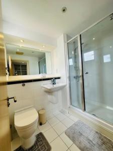 y baño con aseo, lavabo y ducha. en Stylish Zone 2 city Apartment, en Londres