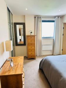 1 dormitorio con cama, tocador y espejo en Stylish Zone 2 city Apartment, en Londres