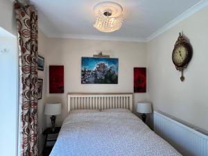 a bedroom with a bed and a clock on the wall at Private Apartment in Windsor in Windsor