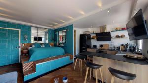 Cet appartement comprend une chambre avec un lit bleu et une cuisine. dans l'établissement Ty Braz 4 pers studio 3 min à pied marché, plage, à La Baule