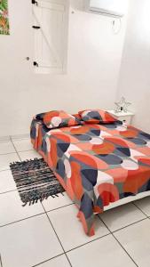Bett mit farbenfroher Bettdecke in einem Zimmer in der Unterkunft Maison de 2 chambres avec piscine partagee jardin clos et wifi a Le Moule a 3 km de la plage in Le Moule