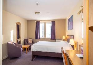 una camera d'albergo con letto e scrivania di V Lodge Manchester a Manchester