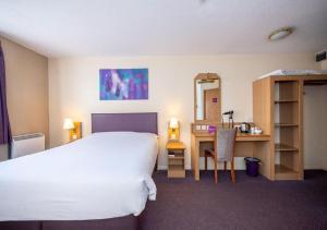 Habitación de hotel con 1 cama, escritorio y 1 dormitorio en V Lodge Manchester en Mánchester