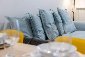 a couch with blue pillows on top of a table at INSIDEHOME Apartments - Val Central in Valladolid +48 photos