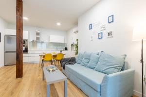a living room with a blue couch and a kitchen at INSIDEHOME Apartments - Val Central in Valladolid