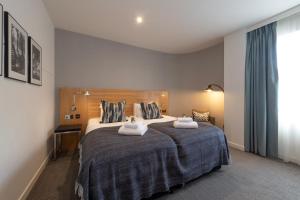 a bedroom with a large bed with two towels at Apex City of Edinburgh Hotel in Edinburgh