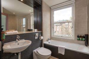 a bathroom with a sink toilet and a window at Apex City of Edinburgh Hotel in Edinburgh +51 photos
