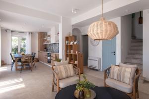 a kitchen and living room with a table and chairs at Villa Thea Mare Maistro by PosarelliVillas in Lákones