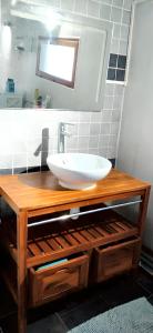 ein Badezimmer mit einem weißen Waschbecken auf einer Holztheke in der Unterkunft Maison de 3 chambres avec jardin clos et wifi a Ecrainville in Écrainville