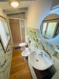 a bathroom with two toilets and a sink and a mirror at Rooftop Cannobio in San Bartolomeo